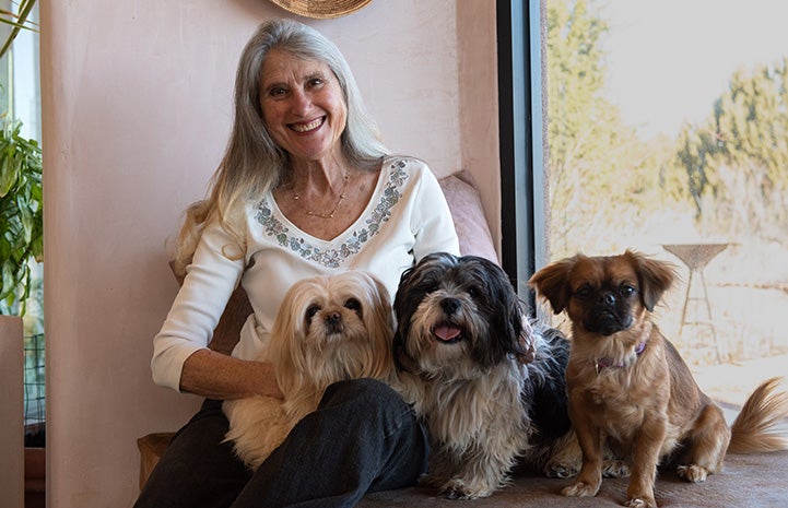 Best Friends co-founder Jana posing with her three small dogs, Sange, Paco and Lula