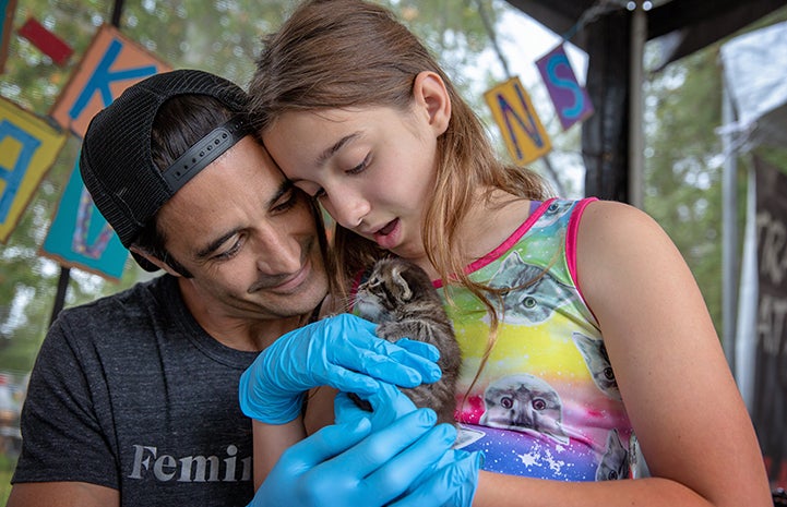 Actor Gilles Marini next to a young girl holding a tabby kitten
