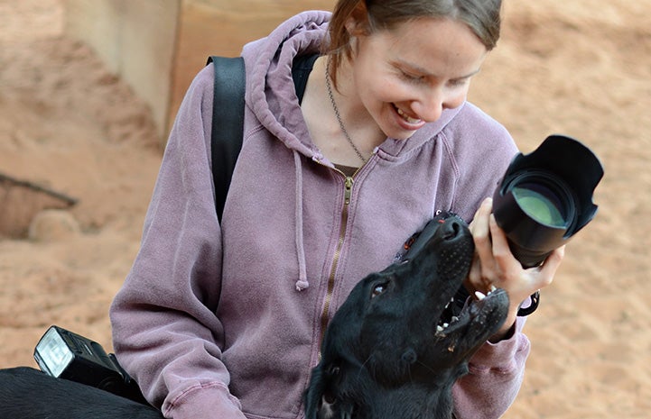 Molly Wald with a camera and a black dog