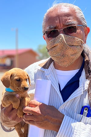 Keith Slim-Tolagai holding a puppy