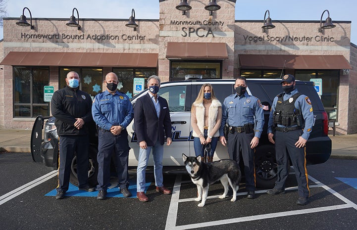 Tala the dog standing in front of a group of people in front of the Monmouth County SPCA building