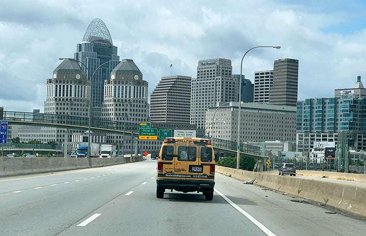 The back of a transport van heading toward a city