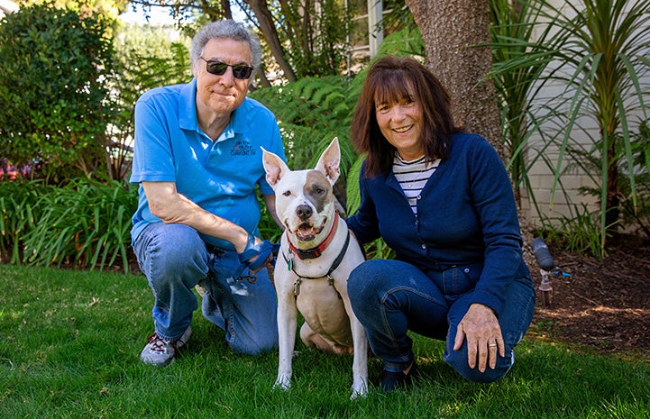 Jewel the dog with her adopted family, all posing for photo outside and smiling