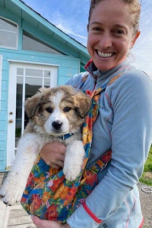 Smiling person holding fluffy puppy Maggie