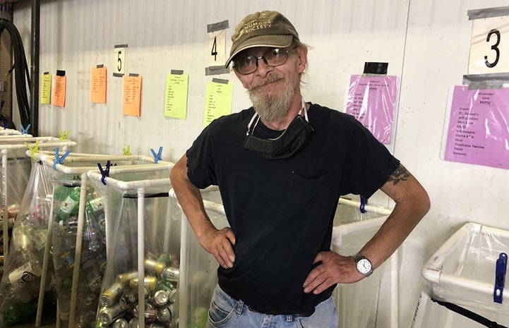 Paul Cooke the volunteer standing in front of recycling bins