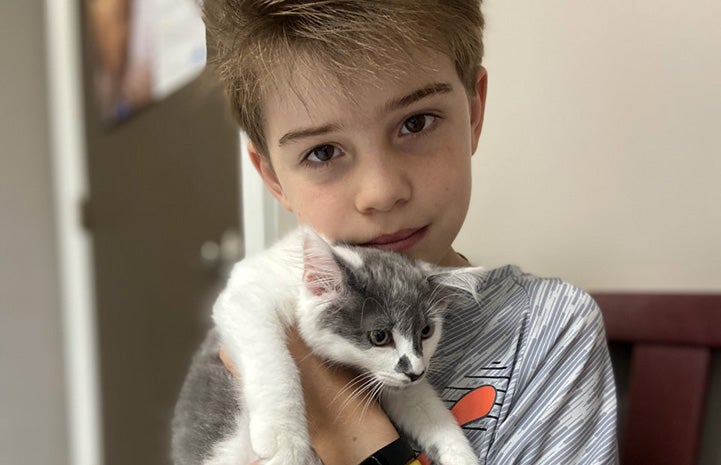 Jonathan holding gray and white kitten Gracie