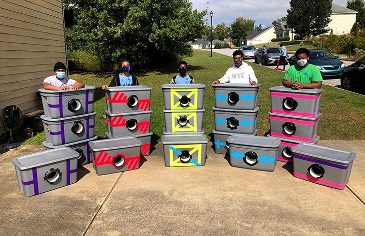 Tyrell Cooper and his Boy Scout Troop posing with the cat shelters they made and donated