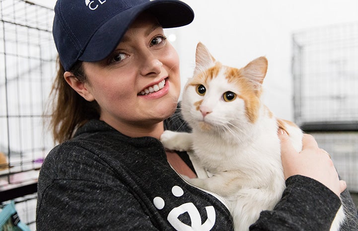 Actor Lauren Ash wearing a Best Friends shirt and holding an orange and white cat
