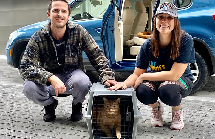 Ellie and Dave with May the cat in a kennel, who they adopted