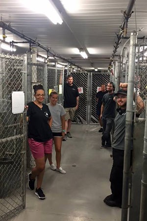 Staffers at Pitt County Animal Shelter standing in front of empty kennels