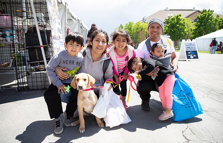 Young family adopting a yellow Lab mix puppy at the NKUT Super Adoption