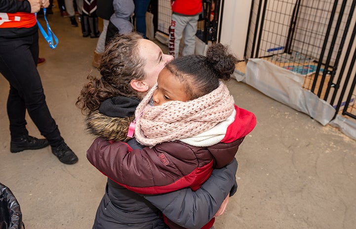 A woman hugging a young girl at the Valentine's Day adoption event in New York City