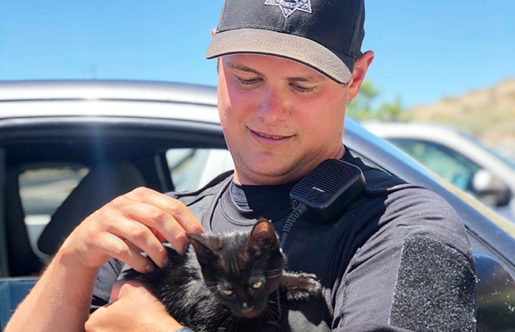 Man holding a black kitten he's adopting from the SPCA of Northern Nevada