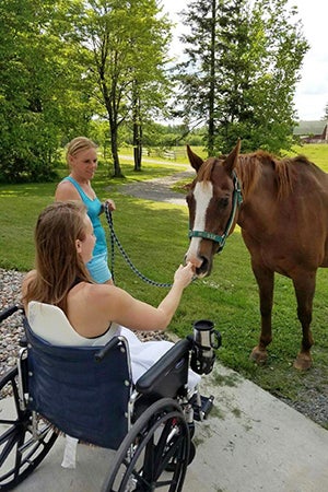 Volunteer Amber Kohnhorst making a friend at Horse Haven
