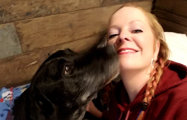 Volunteer Billie Johnson enjoys a adoptable animal sleepover with Nuece the dog