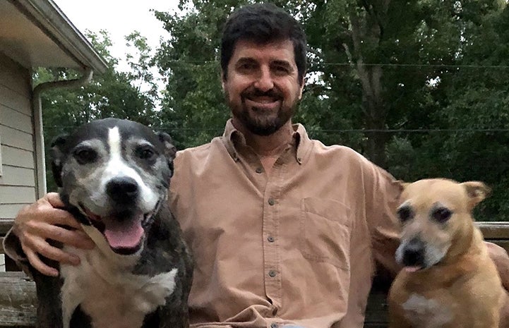 Volunteer Daniel Pruitt surrounded by two dogs