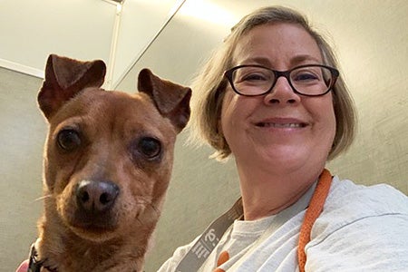 Lillie Schlessinger next to a small brown dog