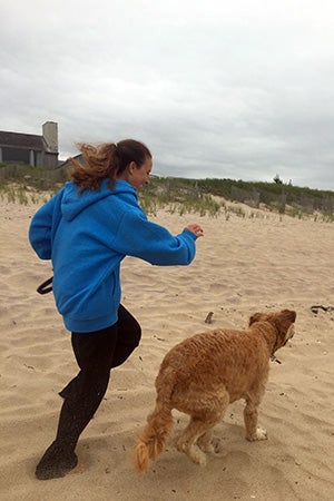 Volunteer Randi Schey running on the beach with a dog