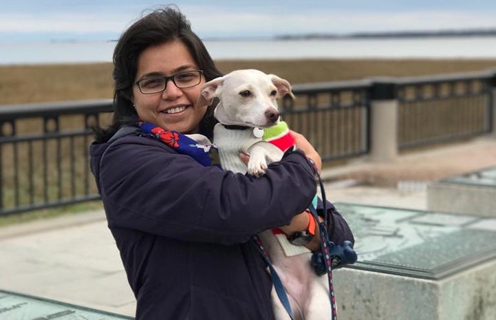 Volunteer Swarnima Singh holding her dog Brodie at the beach