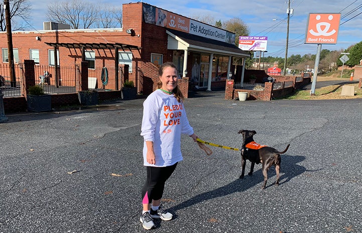 Volunteer Sandy Saffold with a dog in front of the Best Friends Lifesaving Center in Atlanta