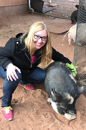 Volunteer Leila Botsford petting Petunia the pig