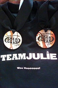 Two marathon medals on top of a Team Julie shirt
