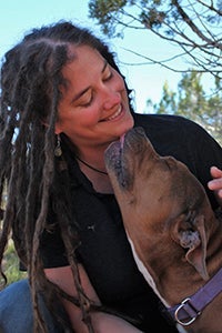Dr. Carley Faughn being kissed on the chin by a dog
