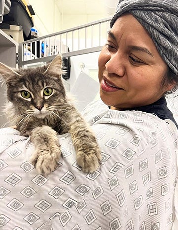 Person holding a cat on her shoulder