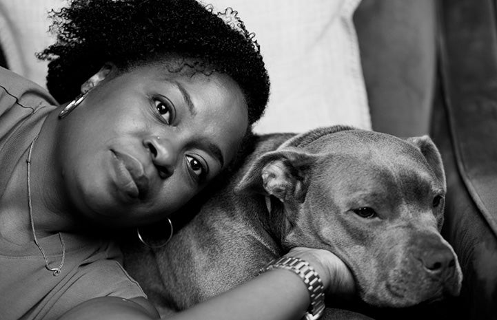 Black and white photo of Ayanna lying next to Dolly the dog