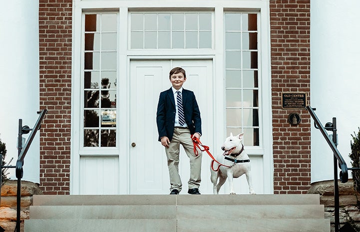 Ethan Branscum with a bull terrier dog at the top of some steps