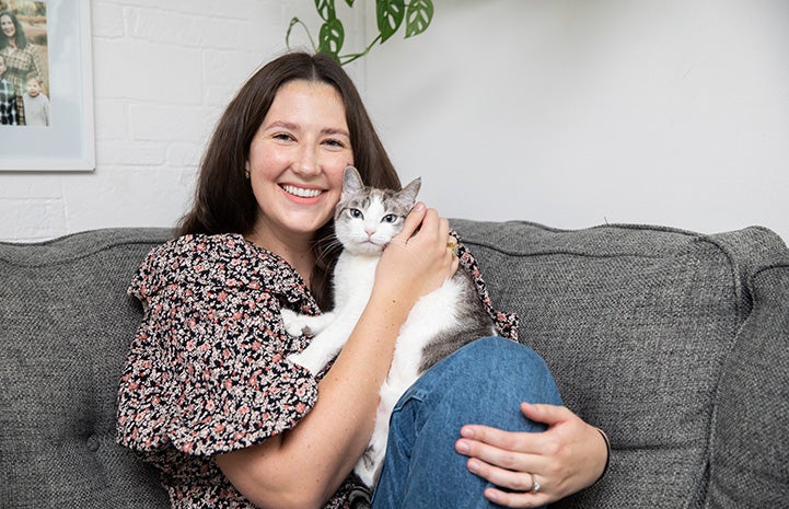 Cat on a person's lap while person hugs the cat