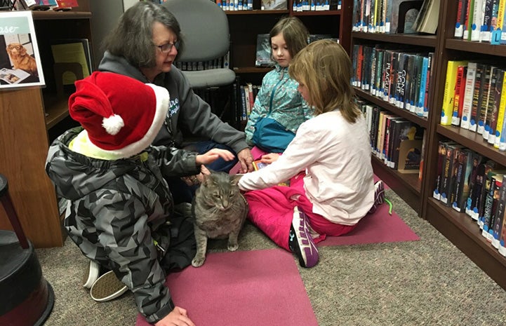 Cherri in a library with kids and Simon the cat