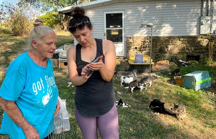 Linda and Jasmine outside with cats in the background