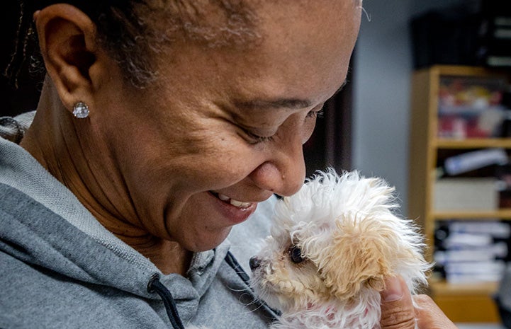 Tammie Sadler looking down and smiling at Bella the puppy