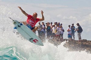 Kelly Slater surfing in front of crowd of onlookers