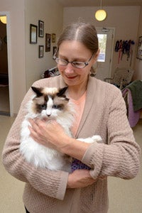 Caregiver holding Montana the special-needs cat