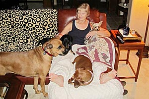 Sue Haynes snuggling with some canine friends on the couch