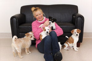 Actress Charlotte Ross visits with some puppies