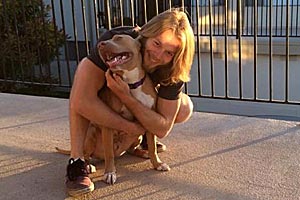 Joseph snuggling with Chata the pit bull who is a service dog