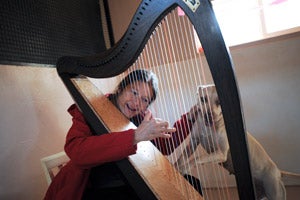 Ellen James plays the harp for Pearl the dog