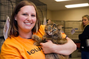 Woman holding the cat she adopted at the pet super adoption at the Utah State Fairpark