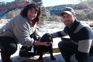 Vicki and James Dixon at Best Friends Animal Sanctuary with a black dog