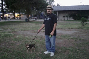 Reece the Chihuahua, who was the 4000th adoption, walking with Mr. Hernandez