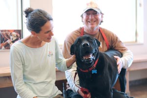 Hatch the dog recovering after his surgery and receiving some love from a veterinarian and caregiver