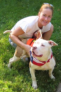 Woman and white and tan pitbull at an adoption event