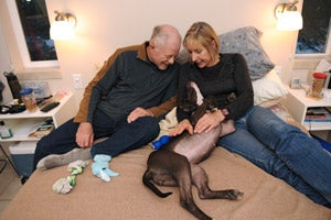 Melanie and John, a couple who volunteer together, enjoy time with Saydi the dog