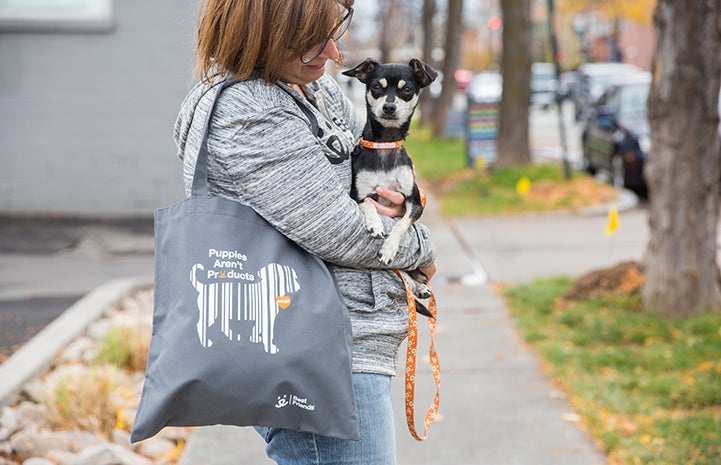 Woman holding a dog and a puppy mill advocacy tote