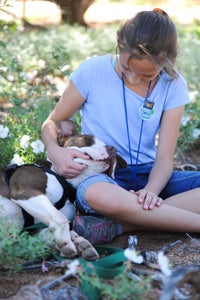 Preteen Danica petting Phinny the dog while volunteering at Best Friends Animal Sanctuary