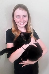 McKenzie Howard, community cat advocate of Layton, Utah, holding a black cat