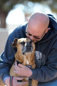 Layla the Vicktory dog getting a snuggle from Kevin